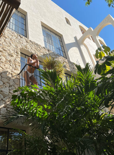 Woman standing on the bedroom patio while overlooking the outdoor area.